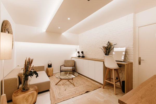 Loge avec mur de brique blanche table en verre et tapis en rotin- U design paris - agence d'architecture à Paris - rénovation d'un immeuble de bureaux pour U2P