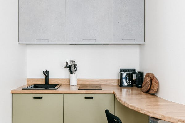 Cuisine verte et béton ciré. Parquet bois et plan de travail cintré épousant le mur