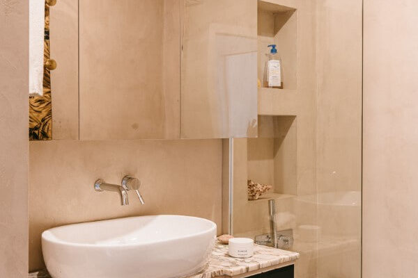 Salle de bains marbre et béton ciré dans un grand appartement entièrement rénové par l'agence d'architecture U design Paris