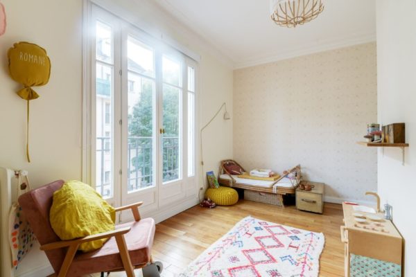 Une ancienne cuisine transformée en chambre d'enfant. Le béton ciré a été recouvert de parquet massif, des rangements et un coin bureaux ont été conçus et ont atmosphère douce et chaleureuse c'est installé dans cet espace aux touches végétales et scandinaves.