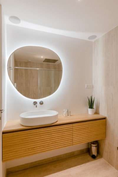 miroir rond et meuble de salle de bains cannelé en bois. Rénovation par l'agence d'architecture u design paris
