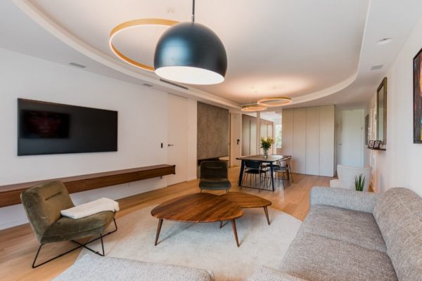 Séjour familial table basse bois triangulaire La redoute intérieurs, fauteuil LPB Paris. Luminaire circulaire Henri Bursztyn, rénovation par l'agence d'architecture u design paris