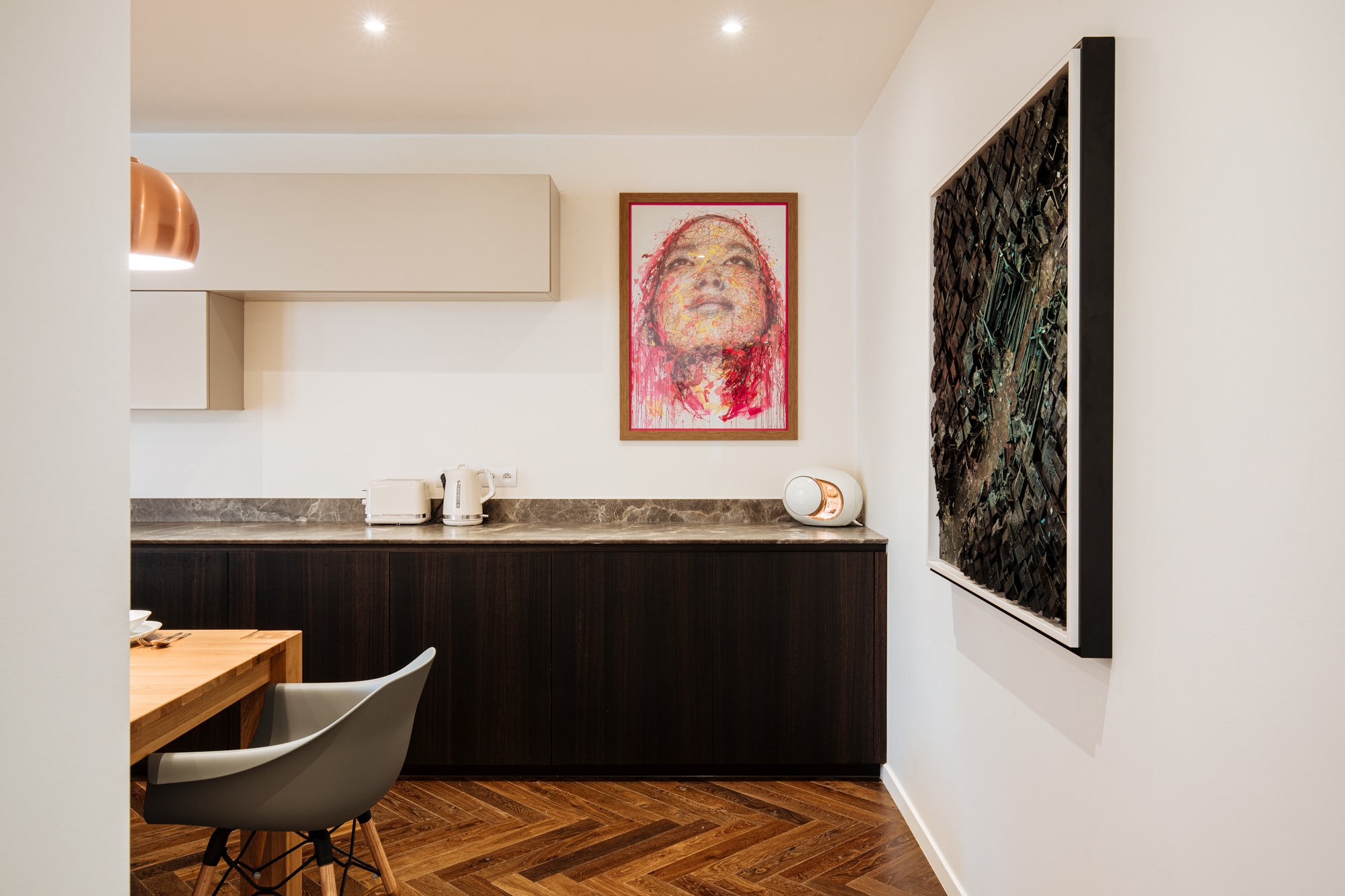 Oeuvre d'art d'Hendrick accrocher dans la cuisine d'un duplex entièrement rénové par l'agence d'architecture U design Paris. Remplacemment d'un parquet chevron et installation d'un mobilier de rangement beige associé à un bois sombre et à du marbre noir