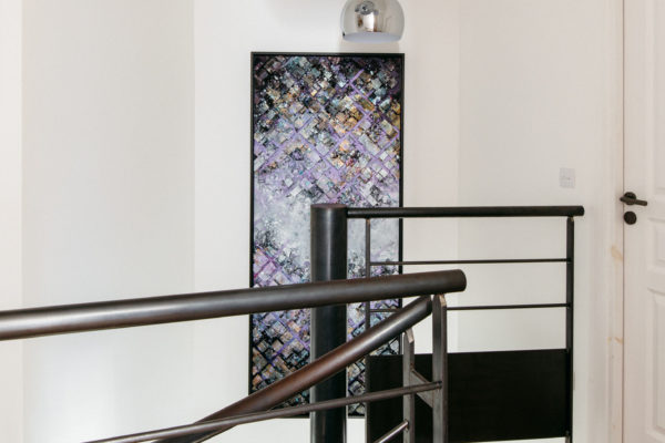 Escalier métallique surmonté d'une suspension mirror balls de tom Dixon et d'un tableau d'Hendrick. une rénovation réalisée par U design Paris