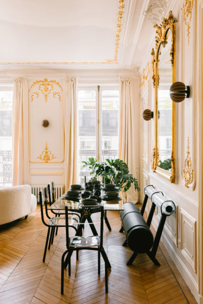 Restauration du grand séjour de l'appartement 100% français : restauration de moulures par un staffeur et des dorures à la feuille d'or. Les trumeaux sont d'époque et ont été rénovés eux aussi. Entourés des appliques RIF, de la Table Clavex de chez Maximum et du banc Mojow, le contraste des époques est parfait. Une rénovation par l'agence d'architecture U design Paris